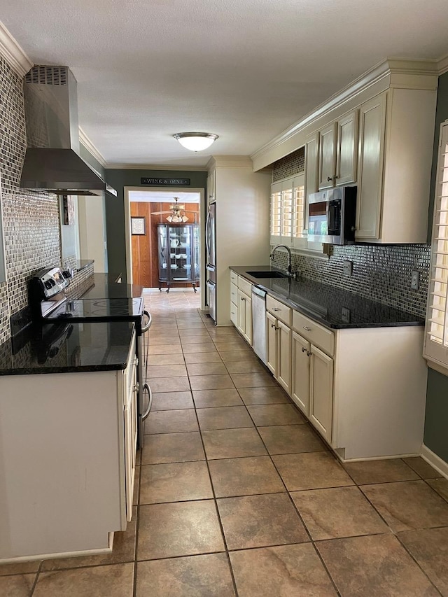 kitchen with sink, wall chimney exhaust hood, stainless steel appliances, tile patterned flooring, and ornamental molding