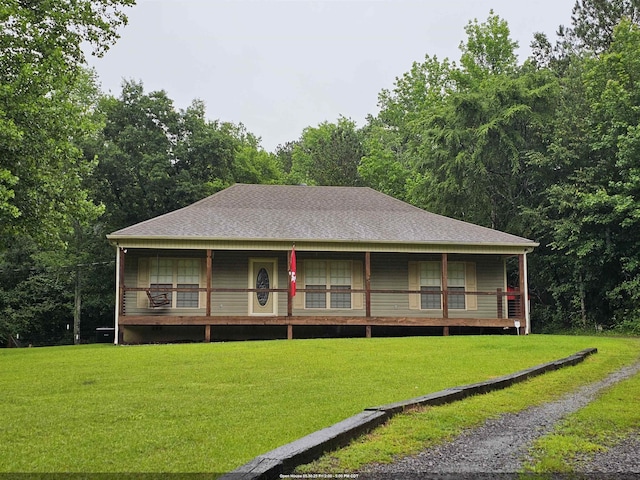  - rear view of property with a lawn, covered porch, and a shingled roof