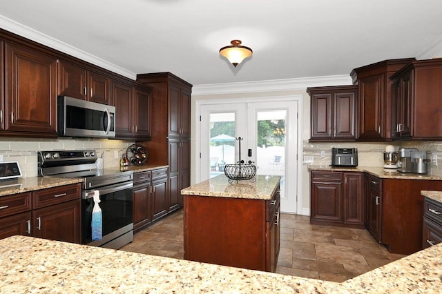 kitchen with decorative backsplash, ornamental molding, appliances with stainless steel finishes, and french doors