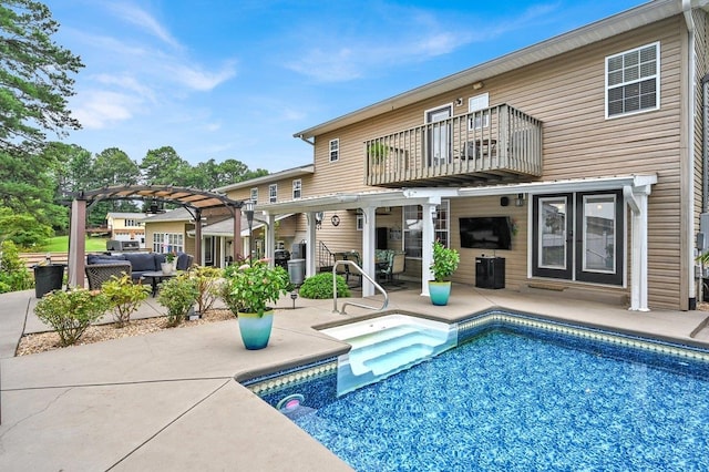 rear view of house featuring a pergola, a balcony, and a patio