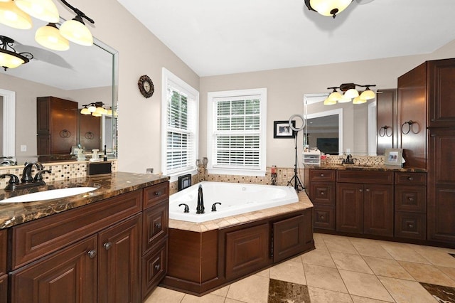 bathroom with tile patterned flooring, vanity, and a tub to relax in