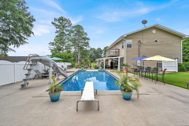 view of pool with a patio area, a diving board, and a water slide