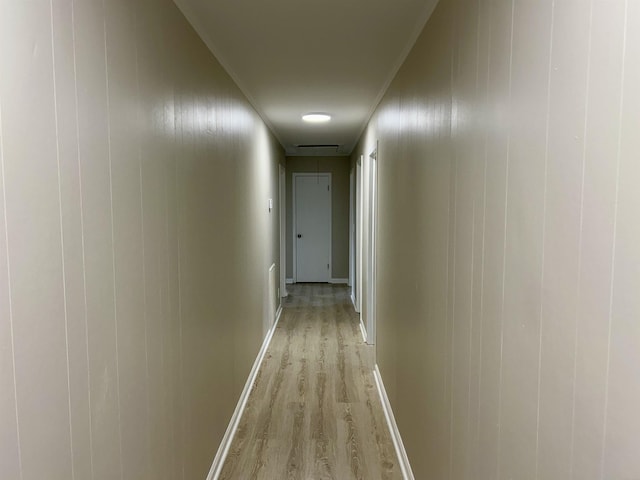 hall featuring light wood-type flooring, attic access, and baseboards