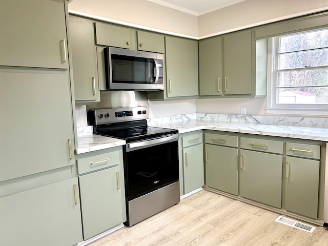 kitchen featuring appliances with stainless steel finishes, visible vents, light wood-style floors, and green cabinets