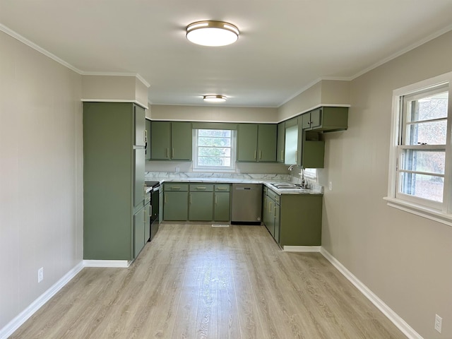 kitchen with light countertops, green cabinets, appliances with stainless steel finishes, a sink, and baseboards