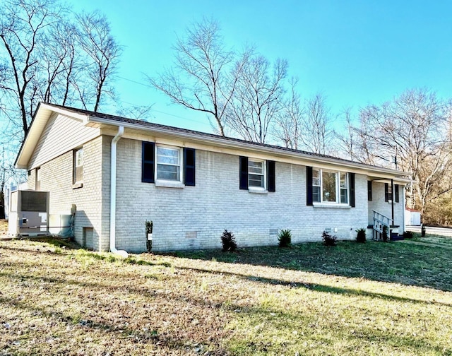 view of property exterior with brick siding, crawl space, and a lawn