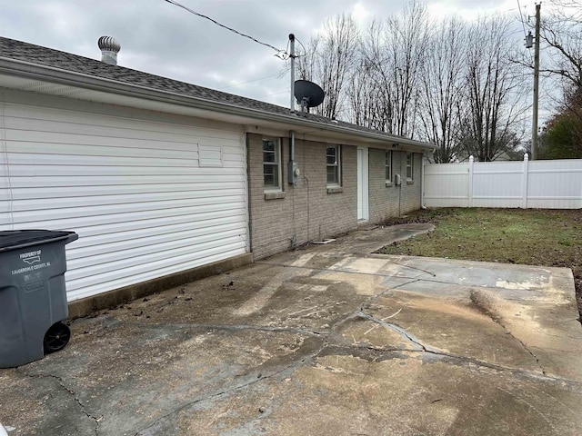 back of property with a patio area, fence, and brick siding