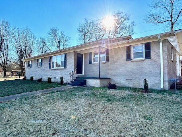 ranch-style home with entry steps, crawl space, brick siding, and a front lawn