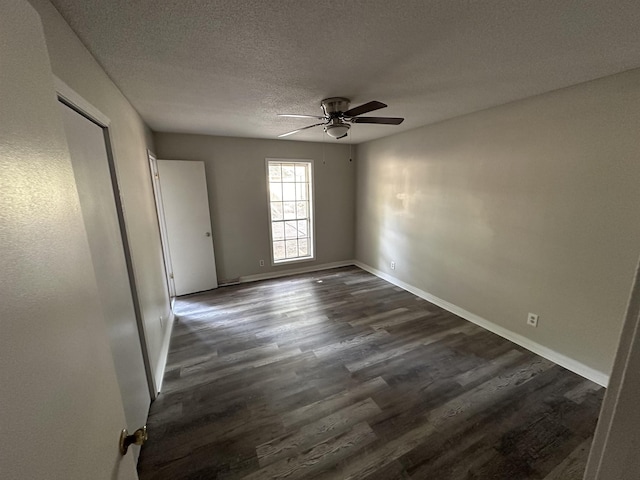 spare room with ceiling fan, dark hardwood / wood-style flooring, and a textured ceiling