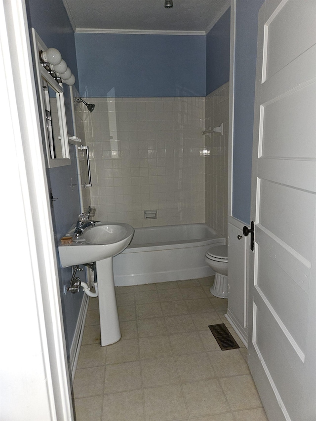 bathroom featuring tiled shower / bath combo, toilet, and ornamental molding