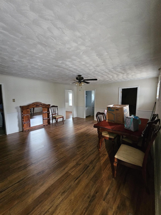 dining area with ceiling fan, dark hardwood / wood-style flooring, and a textured ceiling