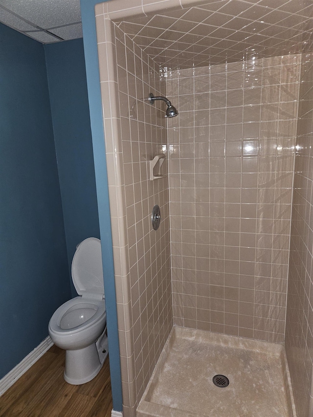 bathroom with tiled shower, hardwood / wood-style flooring, and toilet