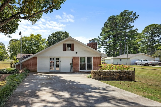 view of front of property with french doors and a front lawn