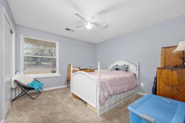 bedroom featuring ceiling fan, brick wall, and light carpet