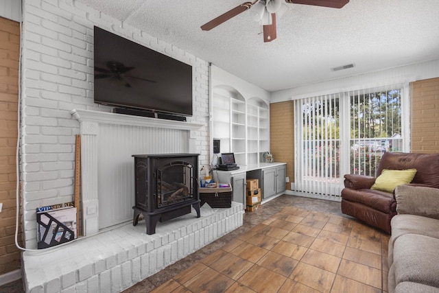 living room with built in features, a textured ceiling, and a wood stove