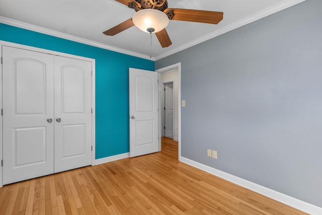 unfurnished bedroom with ceiling fan, a closet, light wood-type flooring, and ornamental molding