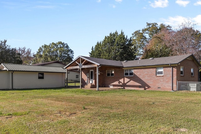 rear view of property featuring a lawn