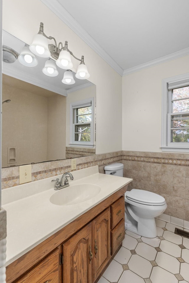 bathroom with crown molding, vanity, tile walls, and toilet