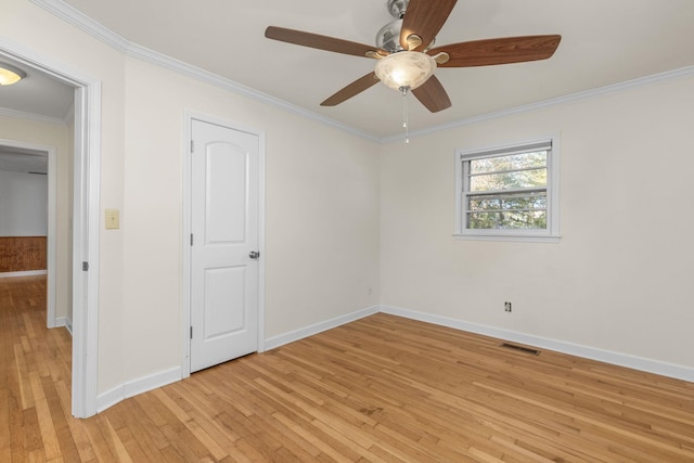 empty room with ceiling fan, light wood-type flooring, and ornamental molding