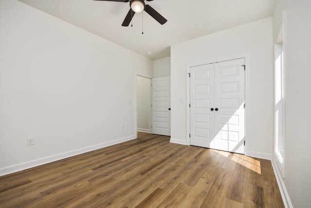 unfurnished bedroom with ceiling fan, a closet, and hardwood / wood-style flooring