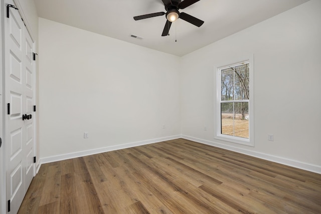 empty room with hardwood / wood-style flooring and ceiling fan