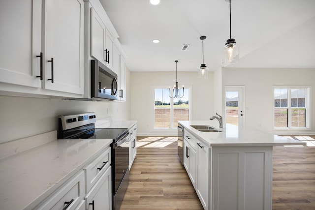 kitchen with pendant lighting, sink, a kitchen island with sink, appliances with stainless steel finishes, and white cabinets