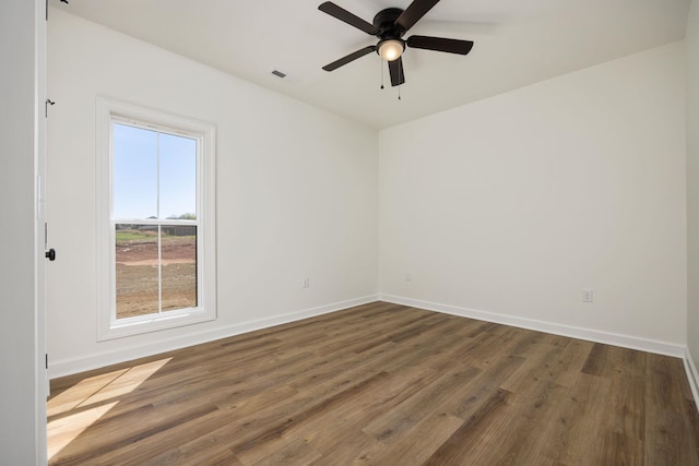 unfurnished room with ceiling fan and dark hardwood / wood-style flooring