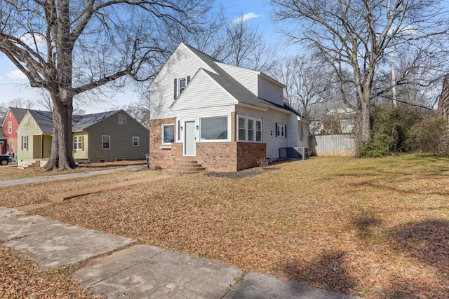 view of home's exterior featuring a yard, fence, cooling unit, and brick siding