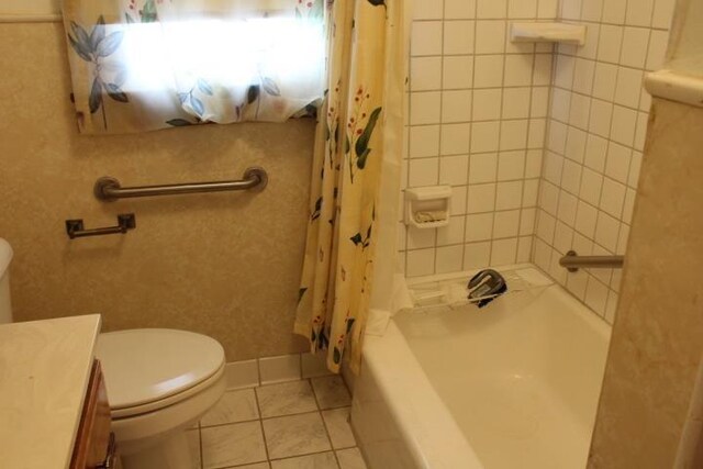 full bathroom featuring toilet, vanity, tile patterned floors, and shower / bath combo with shower curtain