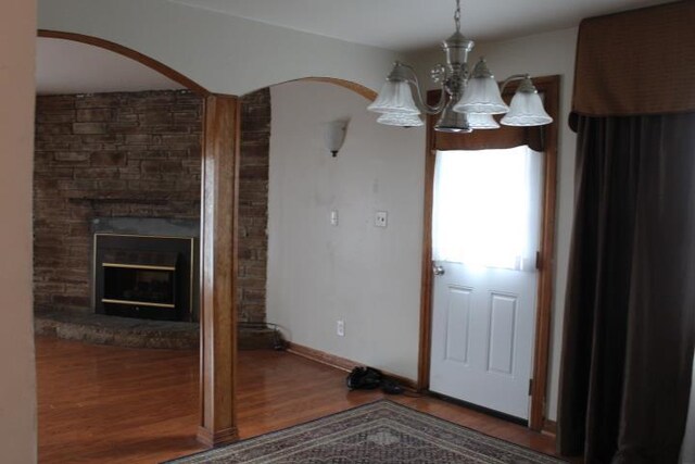 interior space featuring a fireplace, a chandelier, and hardwood / wood-style flooring