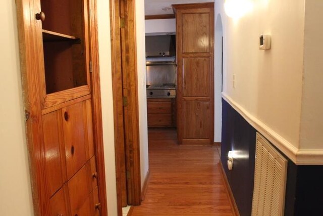 hall with light hardwood / wood-style flooring and ornamental molding