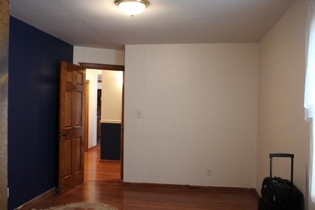 unfurnished room with wood-type flooring