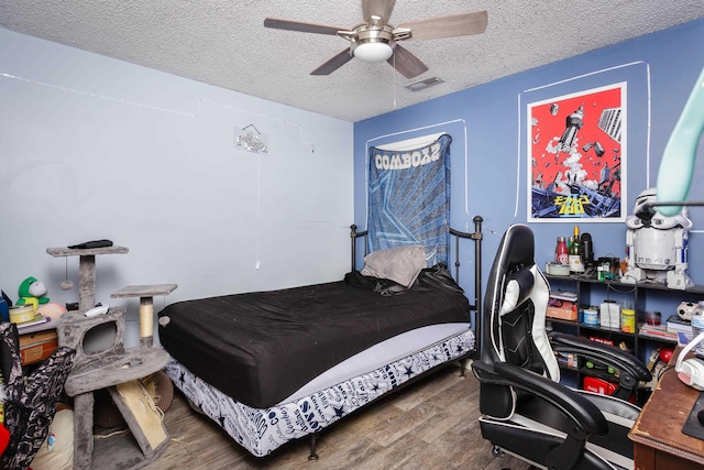 bedroom with ceiling fan and a textured ceiling