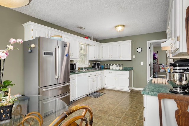 kitchen with white cabinets, sink, a textured ceiling, custom range hood, and stainless steel appliances