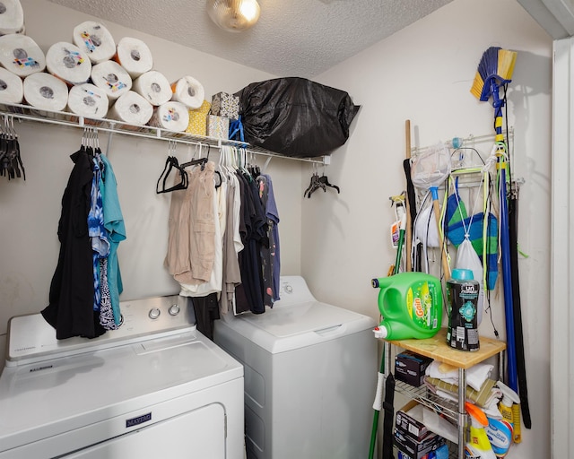 clothes washing area with washer and dryer and a textured ceiling