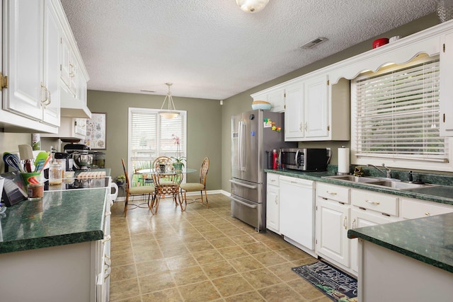 kitchen with sink, pendant lighting, a textured ceiling, white cabinets, and appliances with stainless steel finishes