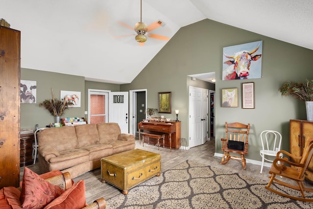 living room featuring ceiling fan, lofted ceiling, and light hardwood / wood-style flooring