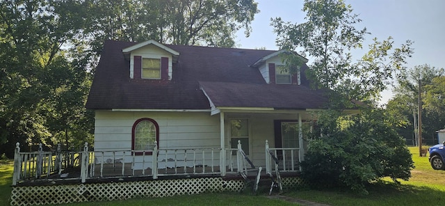 new england style home with a porch and a front lawn