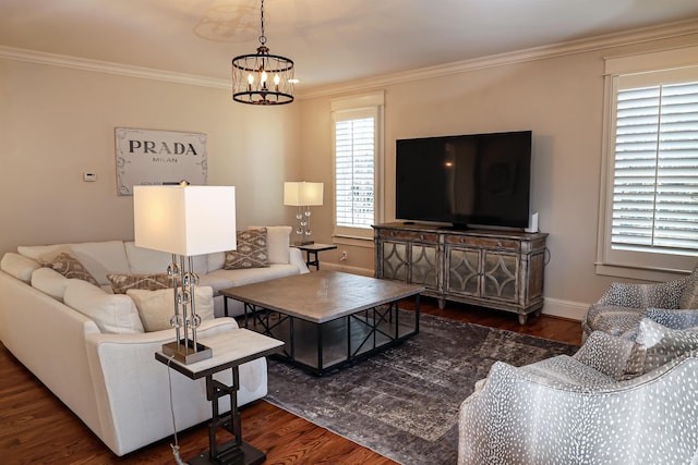 living room with crown molding, a healthy amount of sunlight, and a notable chandelier