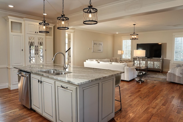 kitchen featuring light stone counters, sink, dishwasher, hanging light fixtures, and an island with sink