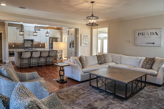 living room featuring a chandelier, dark hardwood / wood-style floors, and ornamental molding