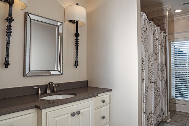 bathroom with vanity, crown molding, and walk in shower