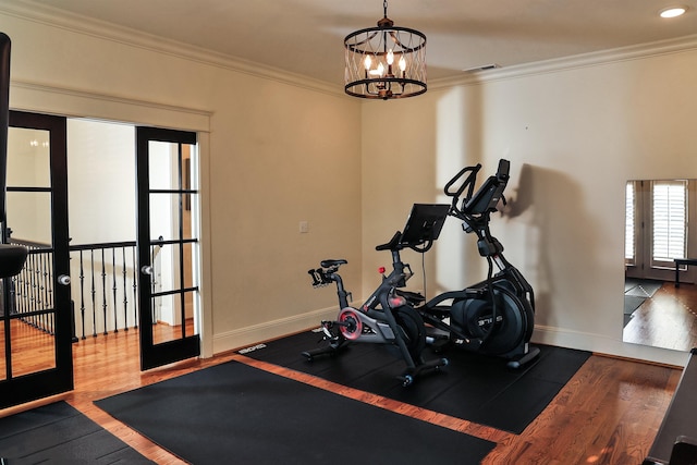 workout area featuring a chandelier, french doors, dark wood-type flooring, and ornamental molding