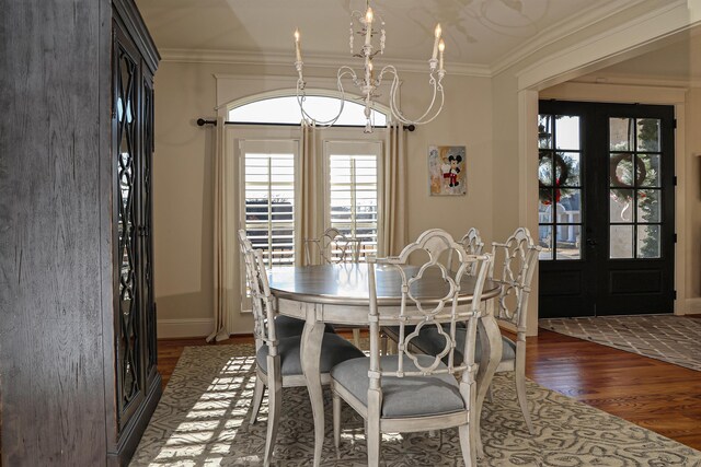 dining room featuring dark hardwood / wood-style flooring, ornamental molding, and french doors