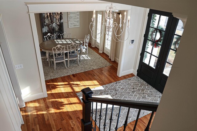 entryway with wood-type flooring and a notable chandelier