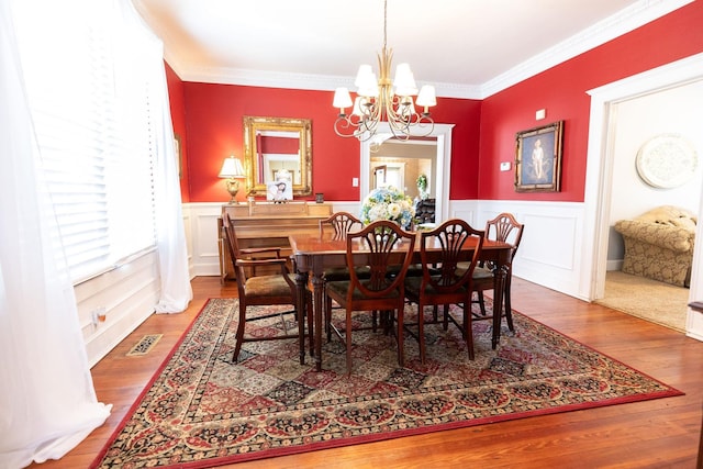 dining area featuring a chandelier, hardwood / wood-style flooring, and ornamental molding