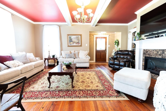 living room with an inviting chandelier, a wealth of natural light, ornamental molding, and a tiled fireplace