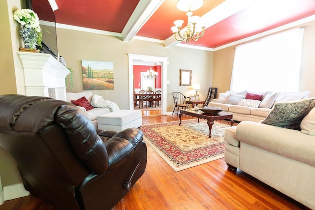 living room featuring a notable chandelier, beam ceiling, wood-type flooring, and ornamental molding