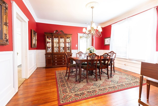 dining room with dark hardwood / wood-style flooring, a chandelier, and ornamental molding