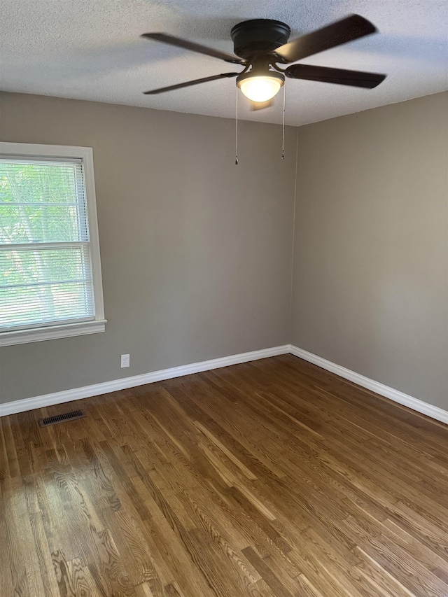  - unfurnished room with a ceiling fan, wood finished floors, baseboards, and a textured ceiling